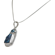 Load image into Gallery viewer, A beautiful rough Neon Apatite pendant accent with a Blue Topaz and elegantly hand set in Sterling Silver bazel.

