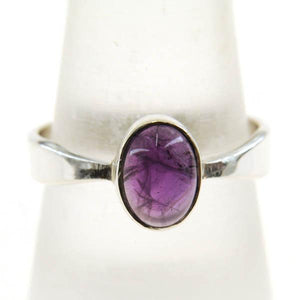 A very delicate ring in sterling silver with two slight curves in the shank and a small oval cabochon stone.